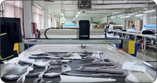 Automated fabric panel cutting in custom sportswear manufacturer bulk production workflow