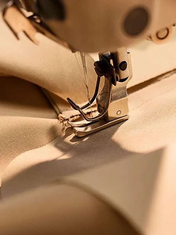 Garment panel stitching under needle for custom sportswear manufacturer production